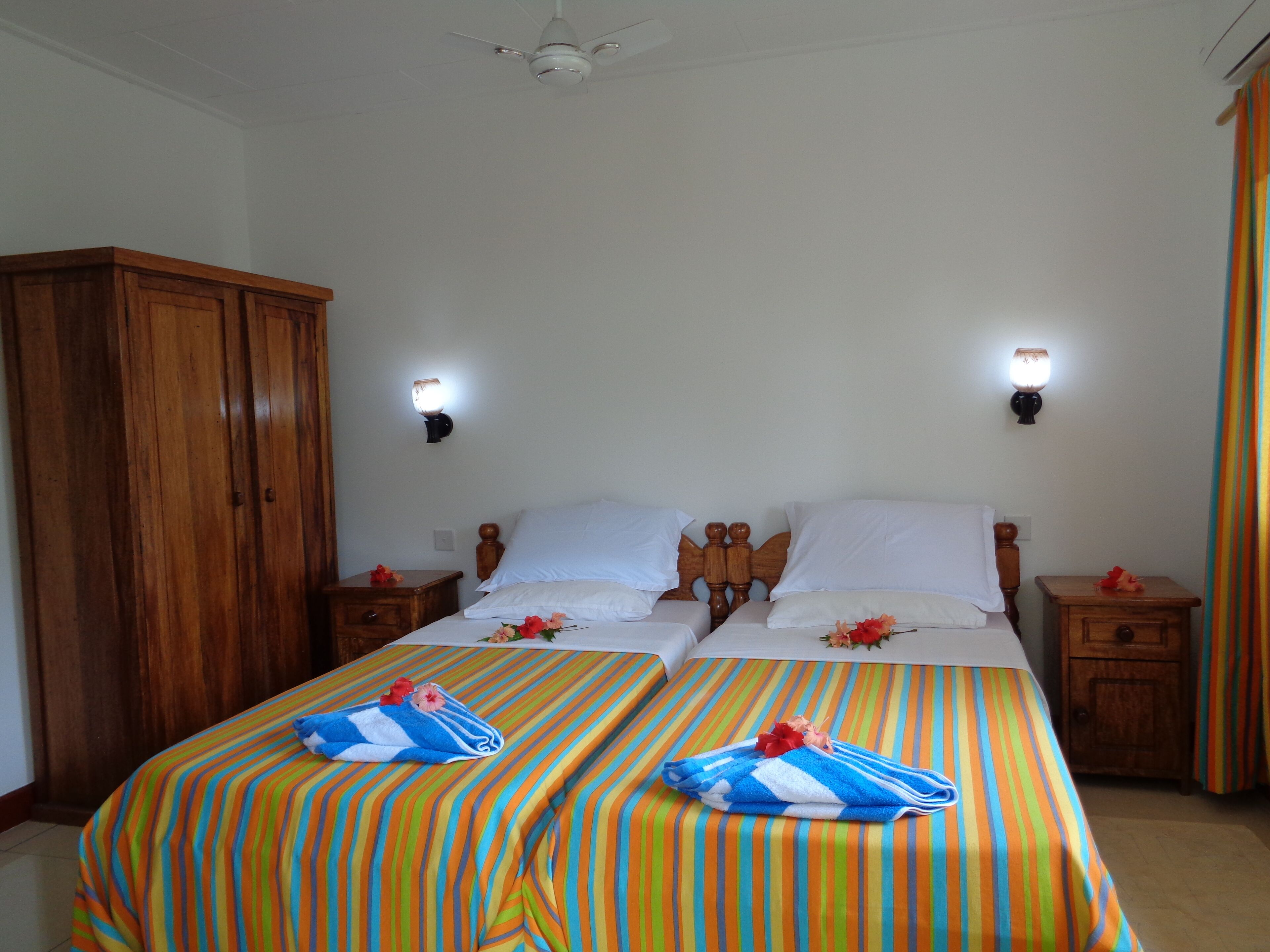 Una habitación de hotel con dos camas, cabeceros de madera y un armario.