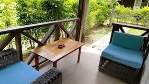 A covered outdoor seating area with wicker furniture and a small table. - Chez Michelin Pension Residence (La Digue)