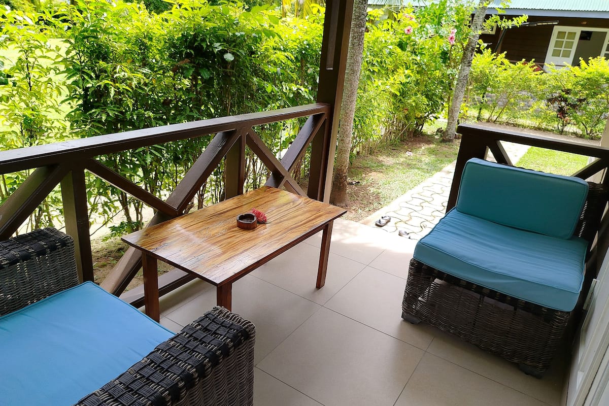 A covered outdoor seating area with wicker furniture and a small table.
