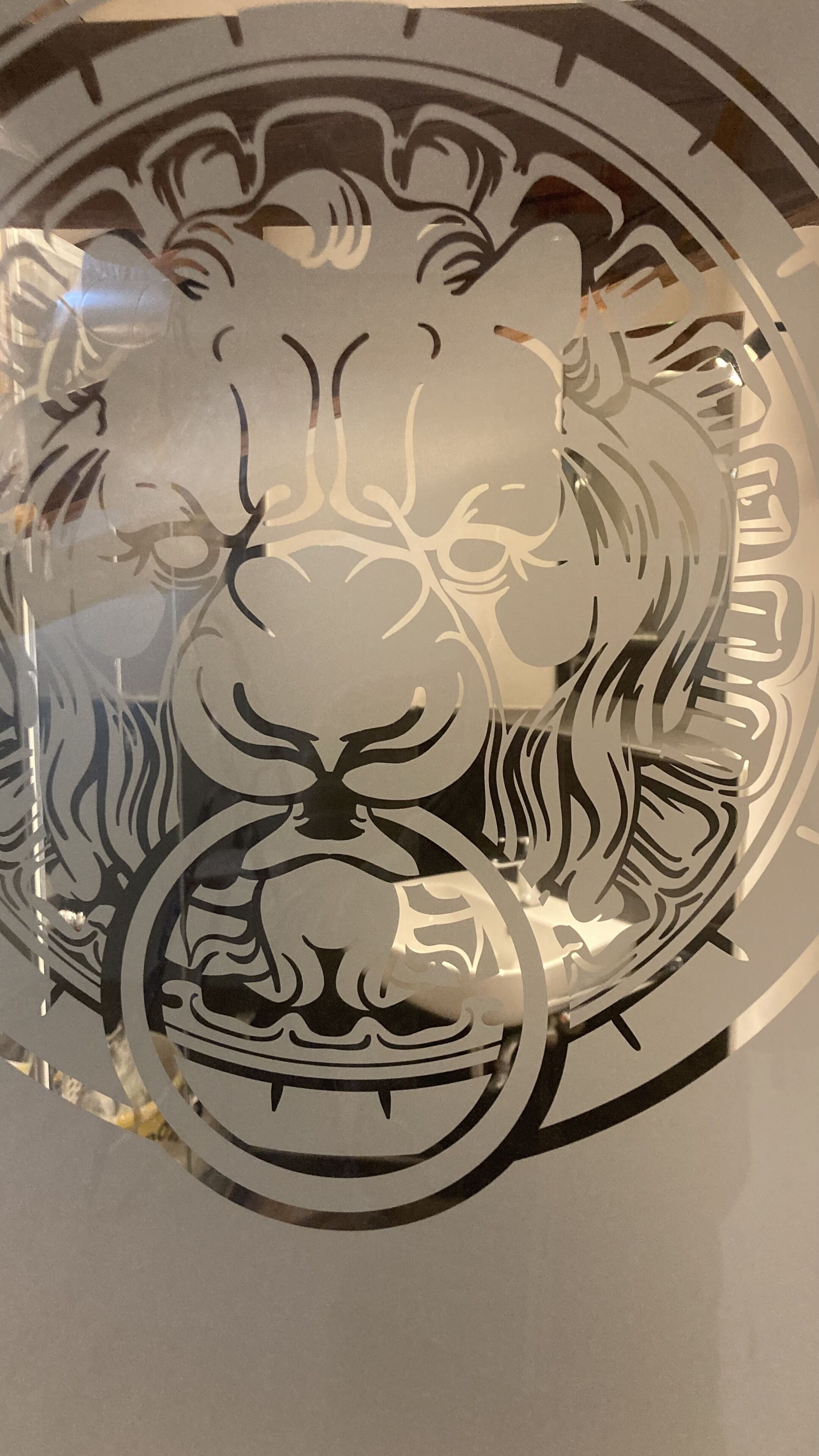 Een rond kunstwerk van metaal met een tijger ontwerp.