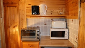 A compact kitchen with wooden cabinets, a toaster, a microwave, and a small refrigerator. - Classic studio for 2 in Tignes (Tignes)