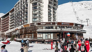 A multi-story hotel with balconies, ski equipment, and a ski slope in the background. - Classic studio for 2 in Tignes (Tignes)
