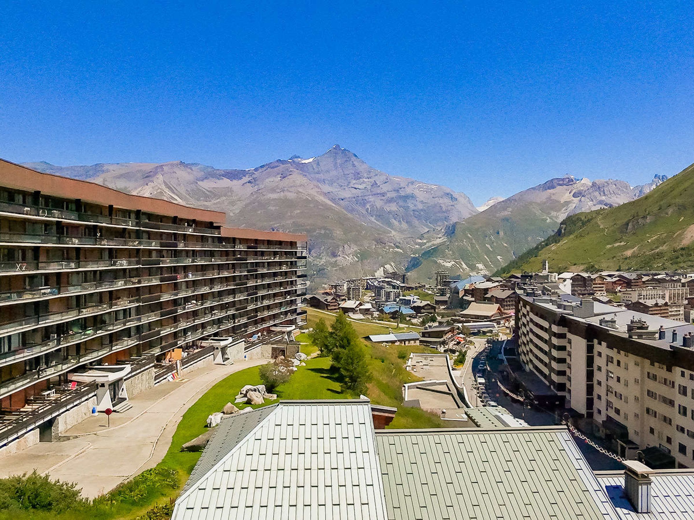 Un hôtel à plusieurs étages doté de balcons, d’un parking et offrant une vue sur les montagnes.