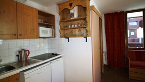 A compact kitchen with wooden cabinets, a microwave, a kettle, and a dishwasher. - Near slopes, 2 rooms for 6 people in Tignes (Tignes-Val Claret)