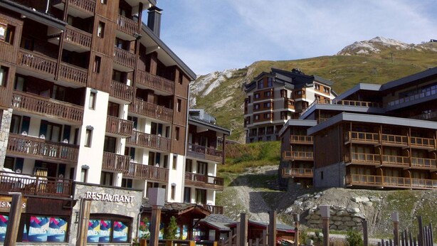 A multi-story hotel with balconies and a restaurant named 'Tignes Tignes' at the ground level. - Near slopes, 2 rooms for 6 people in Tignes (Tignes-Val Claret)
