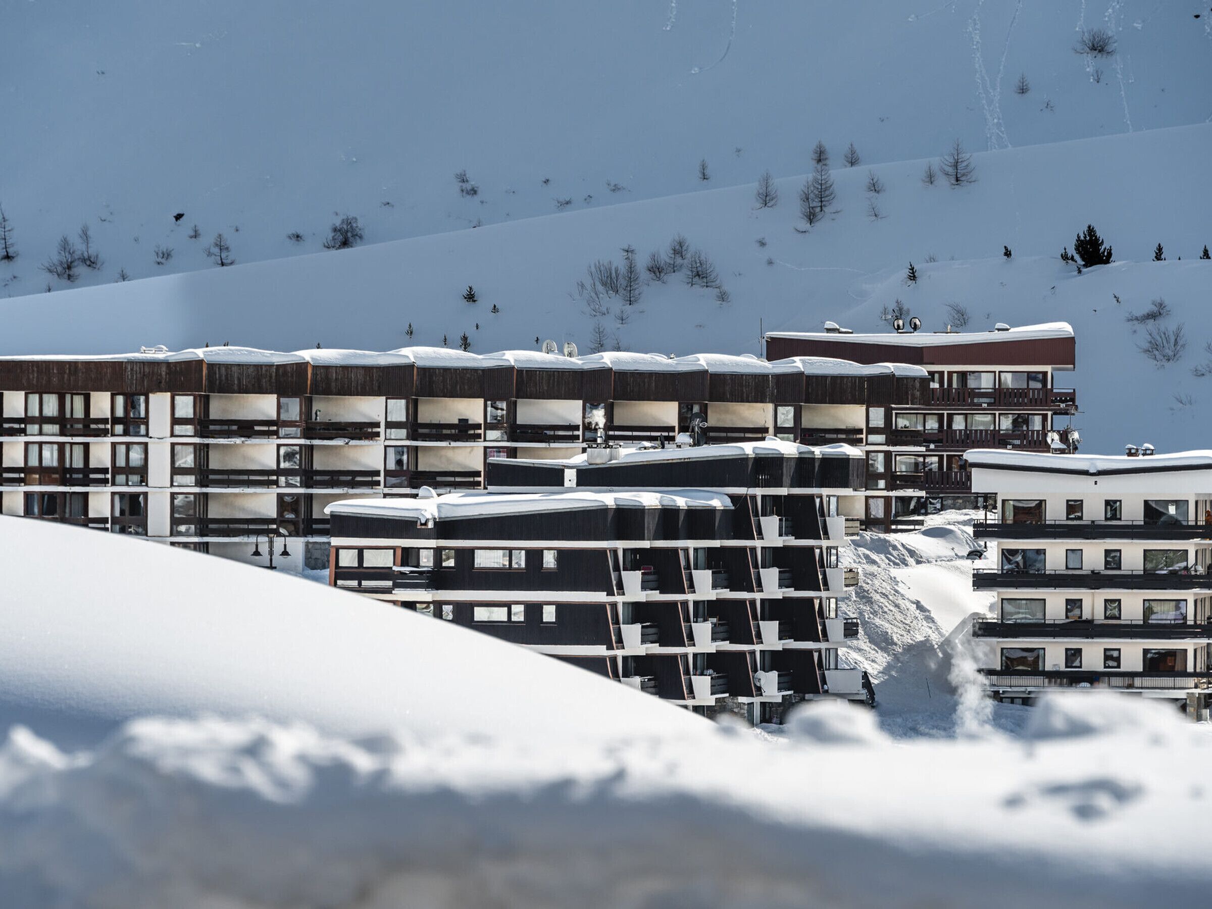 Un hôtel à plusieurs étages doté d’une architecture moderne, avec des balcons et de grandes fenêtres.