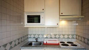 Una cucina compatta con forno a microonde, fornello, lavello e lavastoviglie.