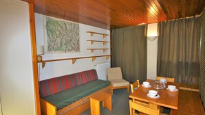 Una stanza accogliente con una panca in legno, un tavolo da pranzo con sedie e un termosifone.