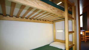 Un letto a castello con materasso verde, testiera in legno e scaletta.