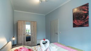 Ein Schlafzimmer mit einem Bett, einem Kleiderschrank, einem Gemälde und einem Spiegel.