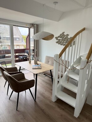 Een modern interieur met een eethoek, een trap en uitzicht op het exterieur.