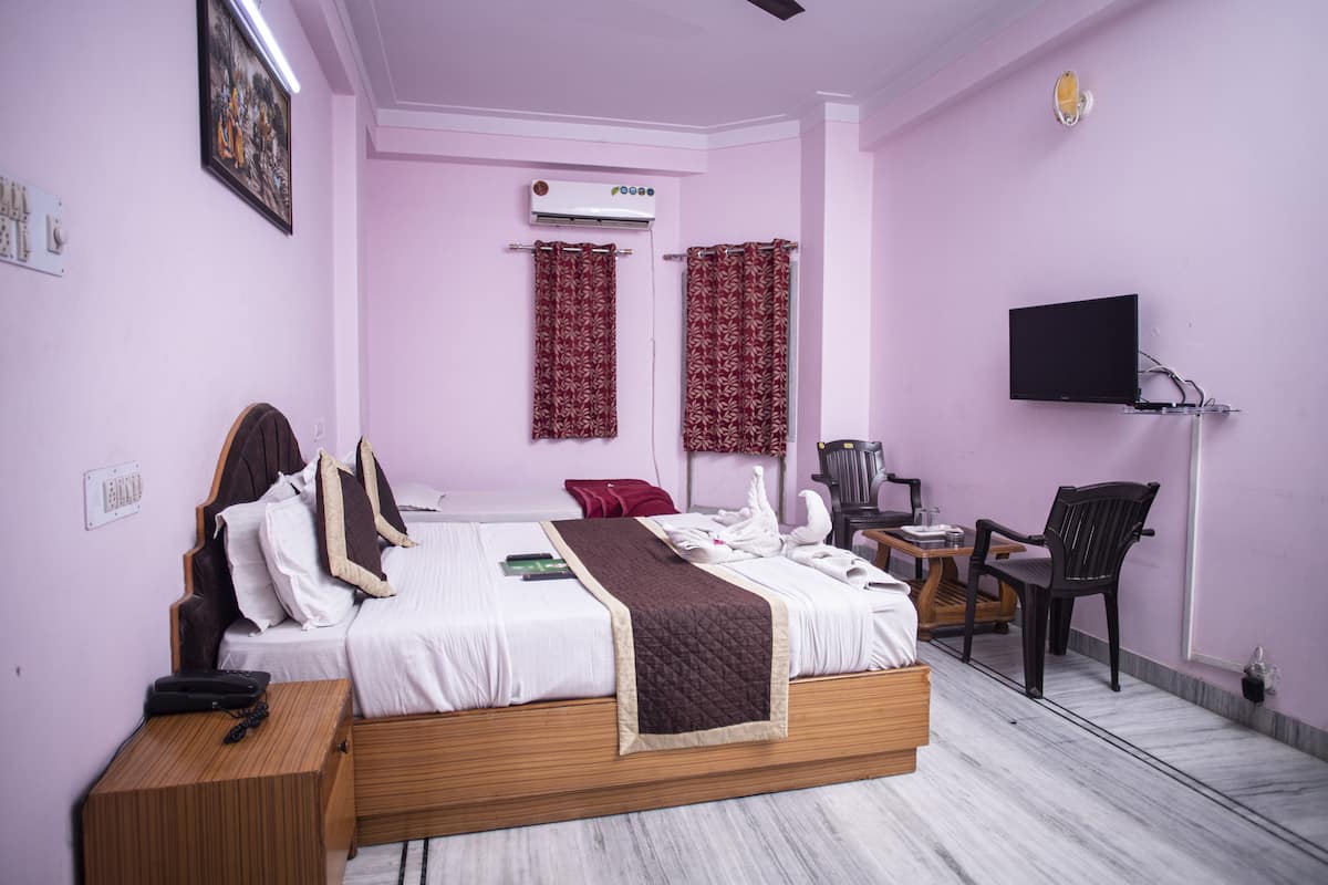 A hotel room with two beds, a flat-screen TV, a desk, and a chair.