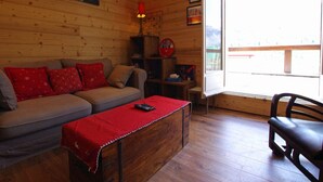 Une pièce chaleureuse avec un décor intérieur en bois, un canapé, un banc et un fauteuil.