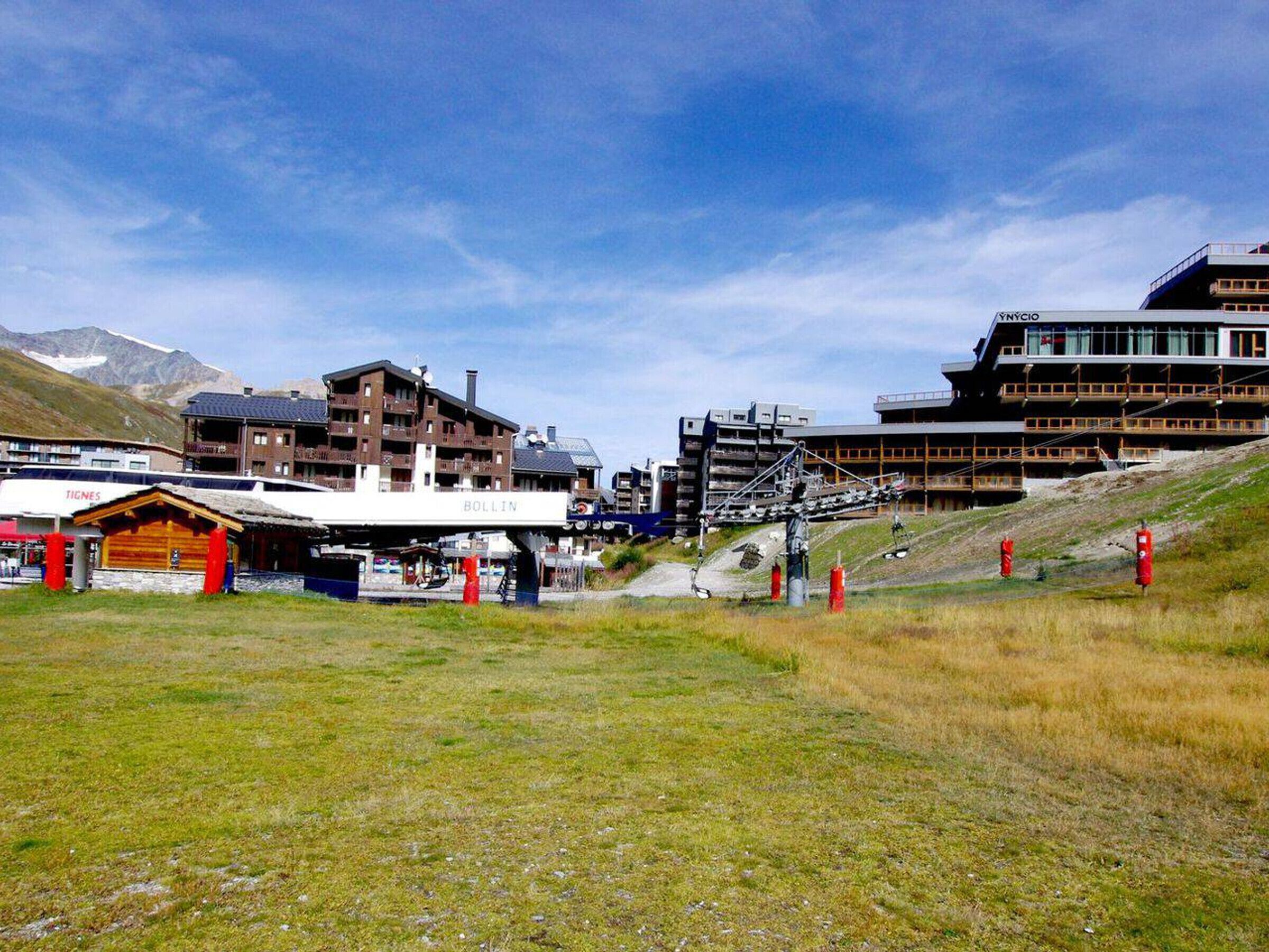 A ski resort with a ski lift, buildings, and a mountain backdrop.