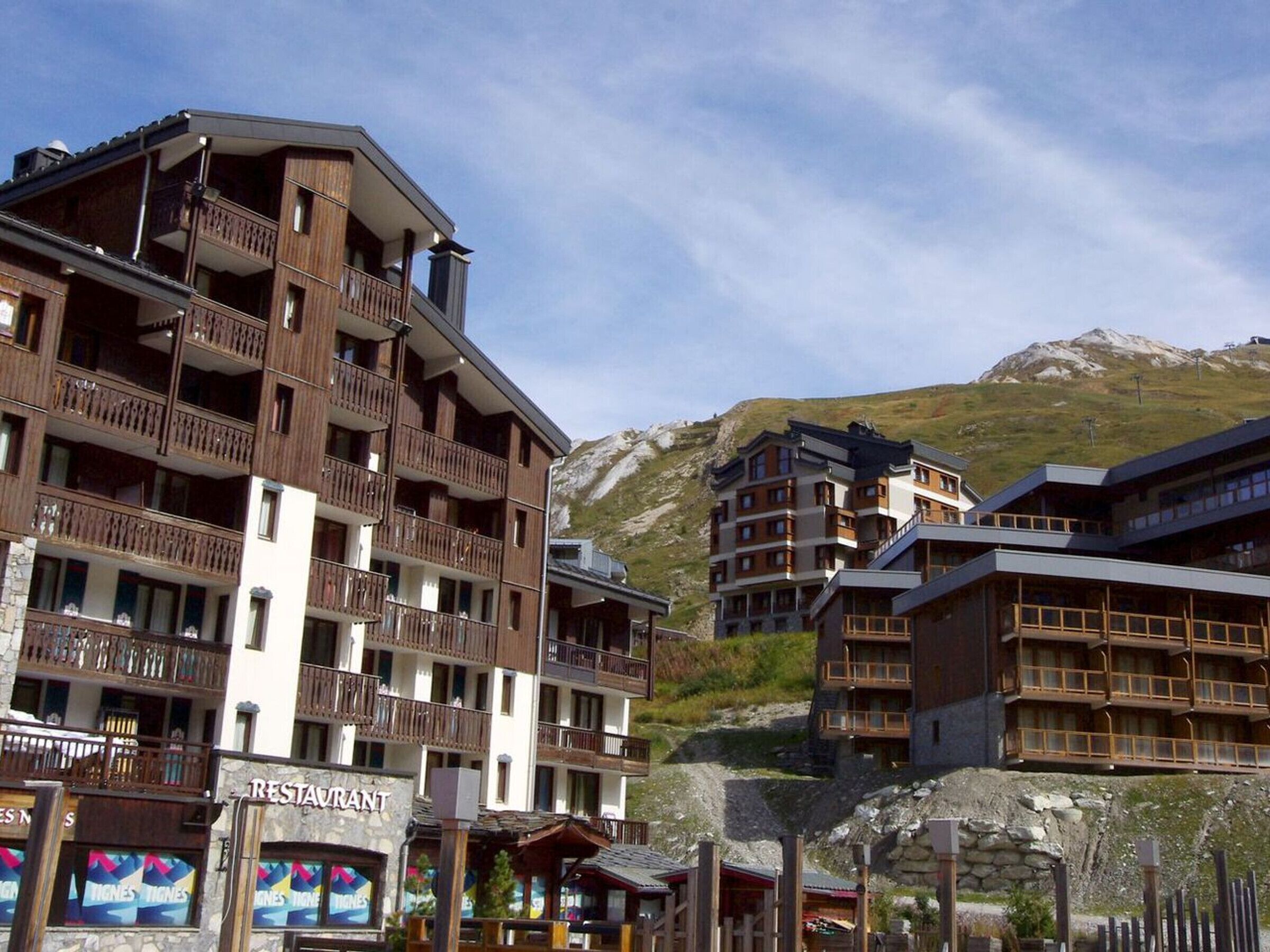 A multi-story hotel with balconies and a restaurant named 'Tignes Tignes' at the ground level.