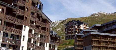 A multi-story hotel with balconies and a restaurant named 'Tignes Tignes' at the ground level.