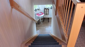 A staircase leading to a dining area with a table and chairs.