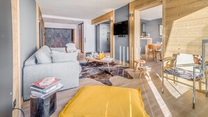 Ein modernes Wohnzimmer mit einem grauen Sofa, einem gelben Überwurf und Holzboden.