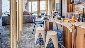 A modern kitchen with a marble countertop, wooden cabinets, and a dining area with a sofa and chairs. - Tignes: Renovated apt, 7 pers, 3 rooms, included services (Tignes)