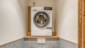 A compact bathroom with a washing machine, a toilet, and tiled walls. - Tignes: Renovated apt, 7 pers, 3 rooms, included services (Tignes)