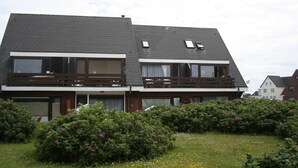 A two-story residential building with a sloped roof, large windows, and a balcony on the upper floor. - App. Feusser - at Wenningstedter Strand (Wenningstedt-Braderup (Sylt))