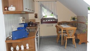 Cocina compacta con comedor, ventana con vistas y un pequeño rincón de descanso.