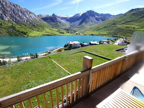 Un balcón con vista a un lago, montañas y edificios.