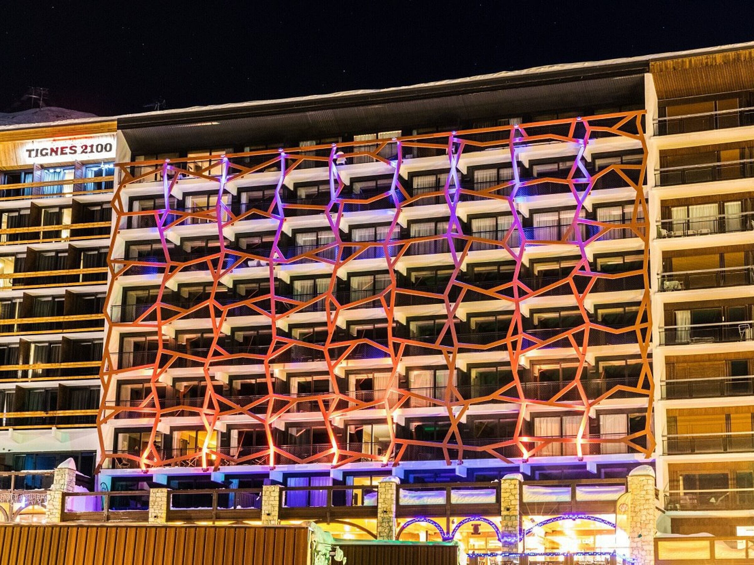 Un hôtel à plusieurs étages, doté d’une façade géométrique remarquable et de balcons.