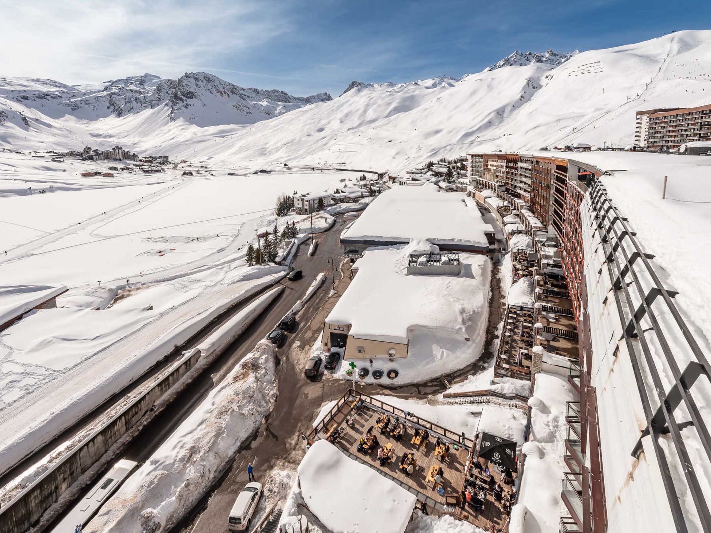 Bergresort bedekt met sneeuw, met een skilift, gebouwen en een heldere lucht.
