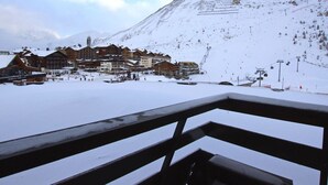 A snow-covered mountain with a ski resort in the foreground, featuring wooden buildings and a ski lift. - Renovated comfy studio 4 ppl with balcony in Tignes (Tignes)