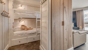 A bunk bed room with a wooden wardrobe, a sofa, and a view of a snowy landscape. - Renovated comfy studio 4 ppl with balcony in Tignes (Tignes)