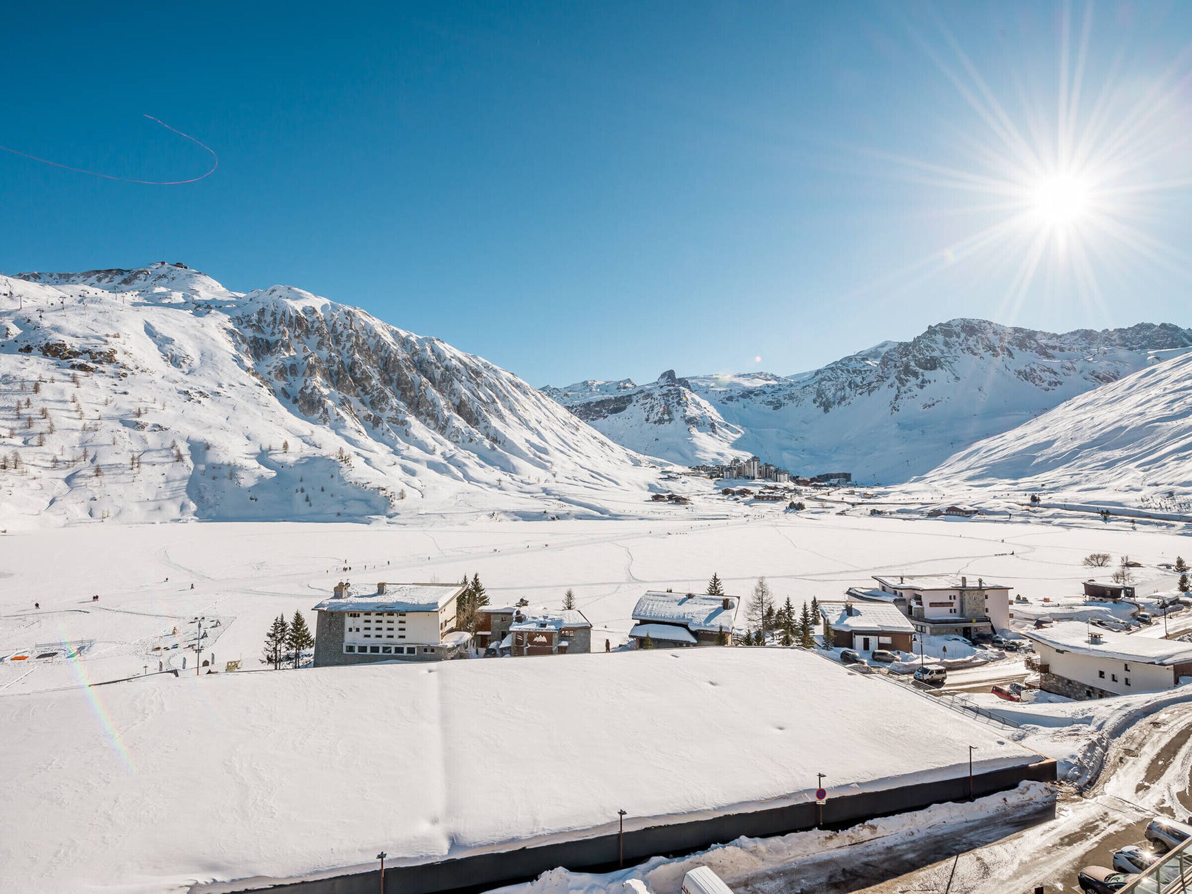 A snow-covered mountainous area with buildings and a clear sky.
