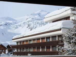 Un hôtel au design moderne, doté d’un balcon et offrant une vue sur des montagnes enneigées.