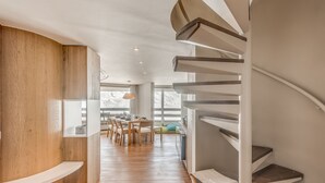 A modern interior with a spiral staircase, wooden flooring, and a dining area with natural light. - Modern Apartment 3* Tignes - 80m² - 8 people (Tignes)