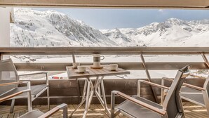 A deck with chairs and a table, overlooking a snowy mountain landscape. - Modern Apartment 3* Tignes - 80m² - 8 people (Tignes)