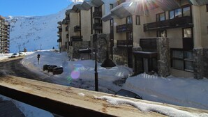 A hotel with multiple balconies, a stone facade, and a view of a snowy mountain. - Renovated 1BR 4 pers in Tignes, south balcony (Tignes-Le Lavachet)