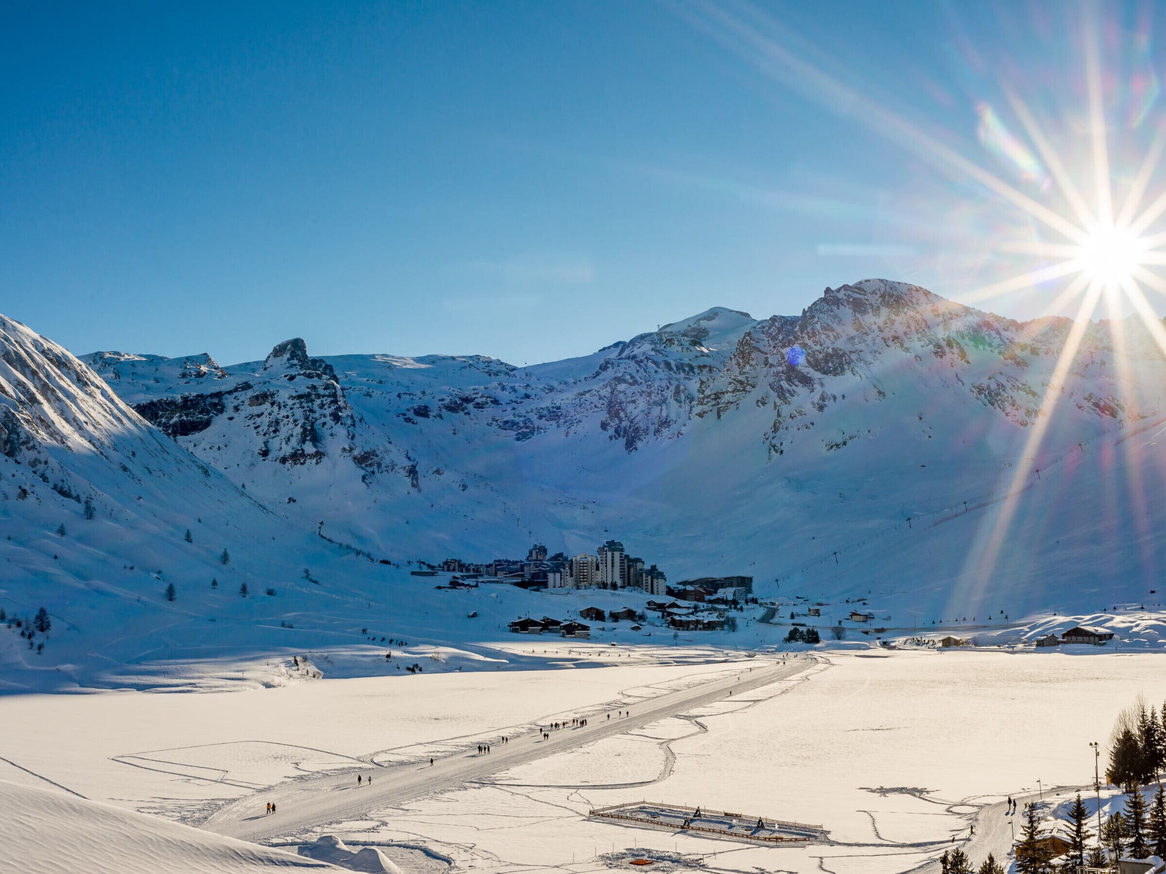 A snow-covered mountain landscape with a ski resort, including ski slopes and buildings.