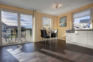 A modern kitchen with a dining area, large windows, and a view of the outside. - Little Venice flat 21 (Ückeritz)