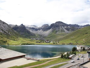 Ein Hotel am See mit Blick auf Berge, ein Parkplatz und eine Straße.