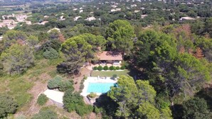 An aerial view of a residential area with a large swimming pool surrounded by dense trees and a few houses. - Villa with panoramic view and huge pool (Saint-Siffret)