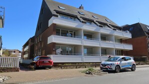 A multi-story residential building with a balcony on the second floor. - App Kapitänsstube, Germany (Sylt)