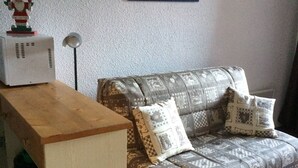 A living room with a sofa, a wooden table, and a decorative item on the table.