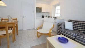 A compact living space with a dining area, a sofa, and a kitchenette. - Spieker Wenningstedt (Wenningstedt-Braderup (Sylt))