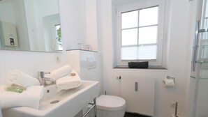 A bathroom with a white sink, a toilet, and a window. - Spieker Wenningstedt (Wenningstedt-Braderup (Sylt))