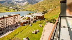 A hotel with a view of a lake and mountains, featuring modern architecture and a parking area.