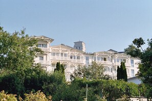 A large, multi-story building with balconies and a tower.