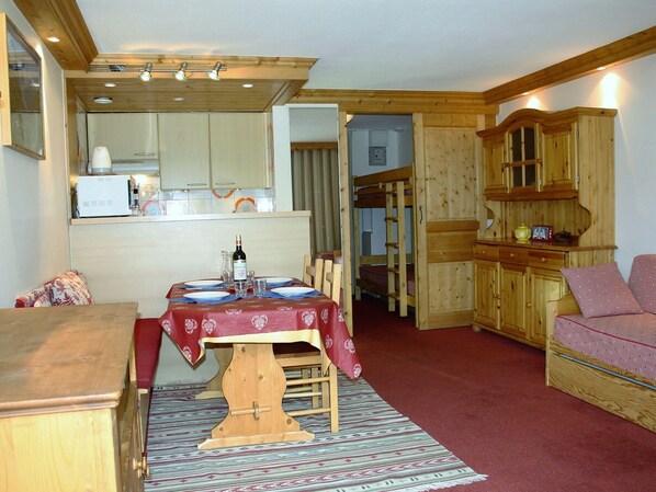 A cozy, compact living space with a dining area, a kitchenette, and a small seating area.