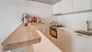 Una cocina moderna con encimeras de madera, electrodomésticos de acero inoxidable y horno empotrado.