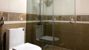 A bathroom with a glass-enclosed shower, a toilet, and a towel rack. - Muong Hoa View Hotel (Sa Pa)
