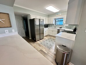 Enjoy cooking in this well-equipped kitchen with a refrigerator, dishwasher, and ample counter space.